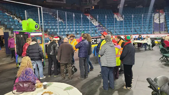 Crowd gathered around the photo booth in an arena, December 2023